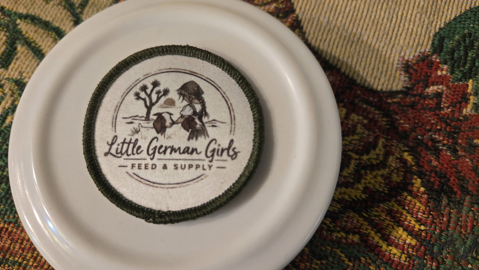 Two-inch Little German Girls Feed and Supply logo iron-on patch